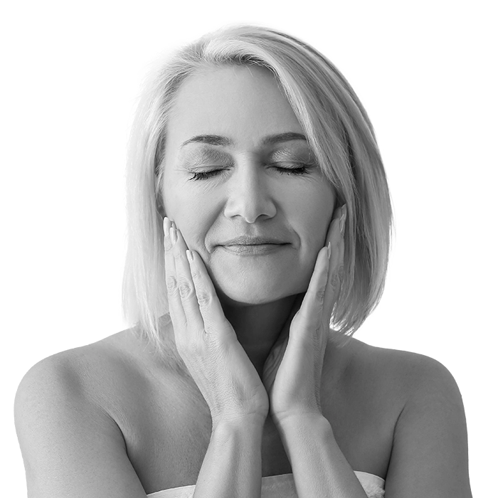 Mature woman giving herself face massage on light background